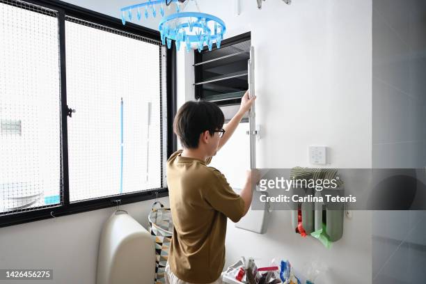 man hanging up a broom after cleaning - utility room stock pictures, royalty-free photos & images