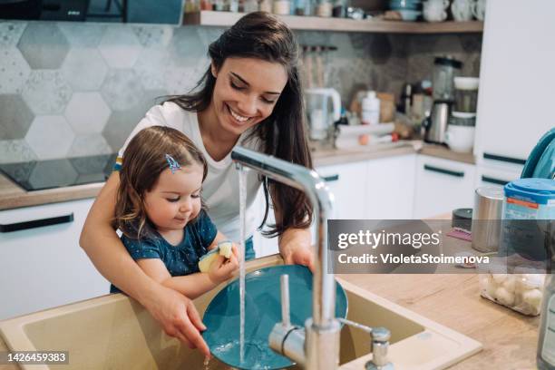 mother and little daughter washing dishes. - child washing hands stock pictures, royalty-free photos & images