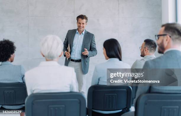 uomo d'affari che parla con un gruppo di persone in una sala conferenze. - discorso programmatico foto e immagini stock