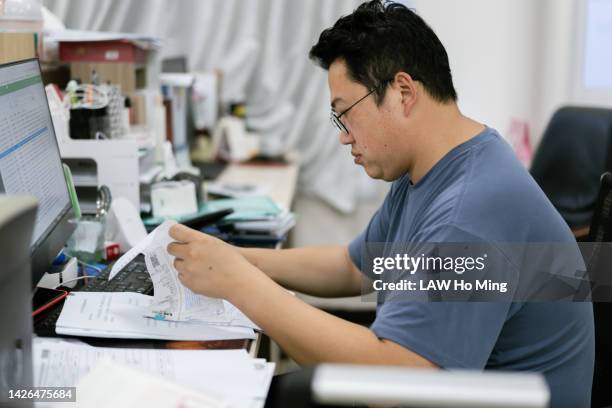 a teacher reviewing documents in the office - secretary of state hillary clinton visits china stockfoto's en -beelden