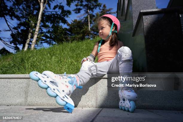 the girl is sitting and resting after roller skating. - inline skate stock pictures, royalty-free photos & images