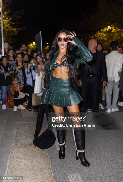 Tinashe wears green skirt, cropped leather jacket, knee high boots, black bag outside Boss during the Milan Fashion Week - Womenswear Spring/Summer...