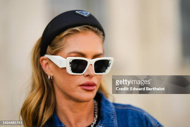 Maja Malnar wears a black puffy headband from Prada, silver earrings, white sunglasses from Prada, a silver necklace, a black transparent t-shirt,...