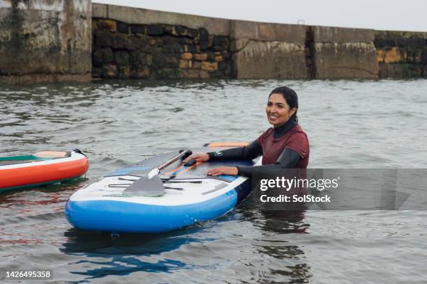 getting back on paddle board - wetsuit stock pictures, royalty-free photos & images