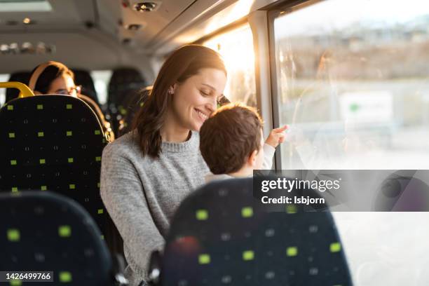 mother and son on a bus looking out of the window - kids sitting together in bus stock pictures, royalty-free photos & images