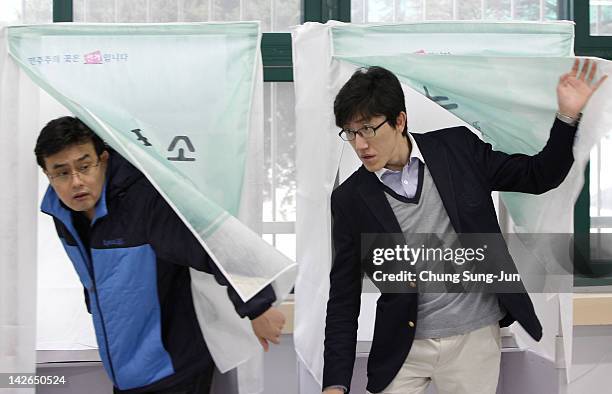 South Koreans cast their votes for new members of the National Assembly in a polling station at the Yuido Elementary School on April 11, 2012 in...