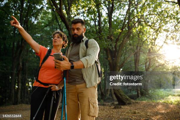 lost hikers contemplating which road to take next on their forest hike - lost generation stock pictures, royalty-free photos & images