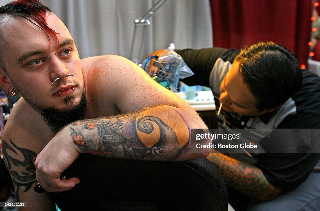Edwin Marquez, right, of Allston, colors in three skulls on the back... News Photo - Getty Images Edwin Marquez, right, of Allston, colors in three skulls on the back... News Photo - Getty Images