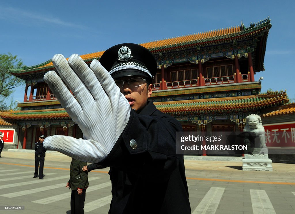 A Chinese policeman blocks photos being