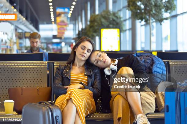 female friedns waiting for flight in airport area - cancellation stock pictures, royalty-free photos & images