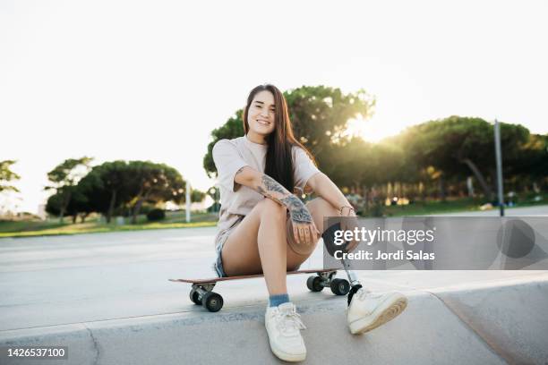 amputee woman with a skateboard in a skatepark - disability rights stock pictures, royalty-free photos & images