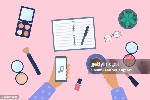bildbanksillustrationer, clip art samt tecknat material och ikoner med high angle view of study desk with female hand holding mobile phone and coffee cup. make-up products, note pad and plant on table - kompakt puder