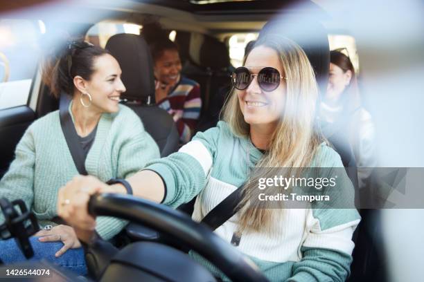 gruppe von freunden auf einem roadtrip in einem auto. - auto freunde stock-fotos und bilder