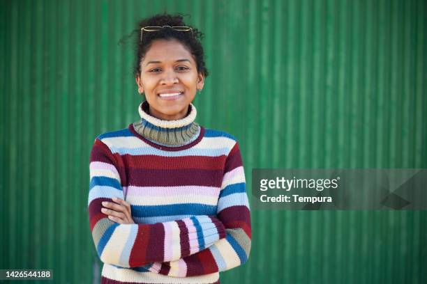portrait of a beautiful woman against a green background. - dominican ethnicity stock pictures, royalty-free photos & images