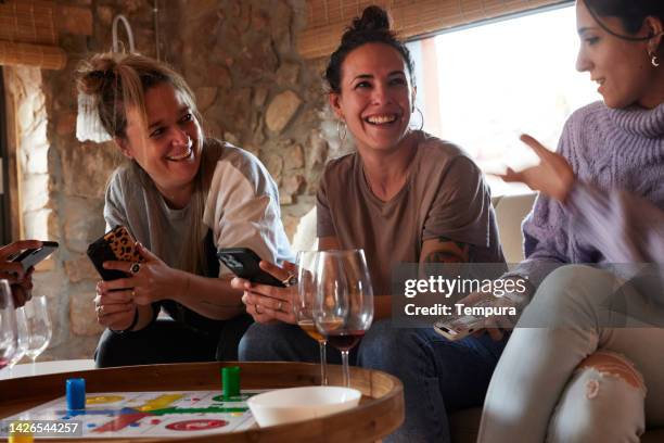 group of friends in a rental apartment playing a board game. - share house stock pictures, royalty-free photos & images