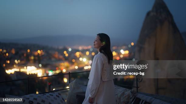 female tourist enjoying looking over city from rooftop of hotel - balcony view stockfoto's en -beelden