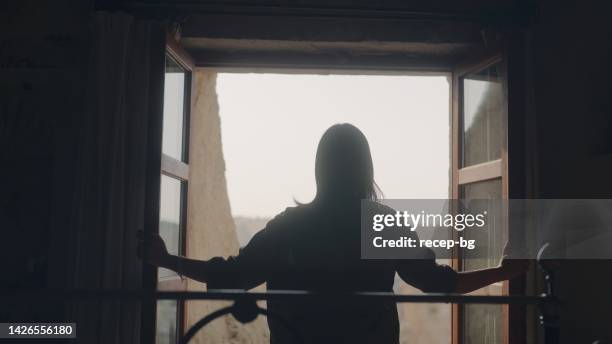 female tourist relaxing in hotel room - behind the curtain stock pictures, royalty-free photos & images