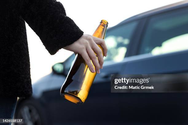 young woman drinking while driving. - dui imagens e fotografias de stock
