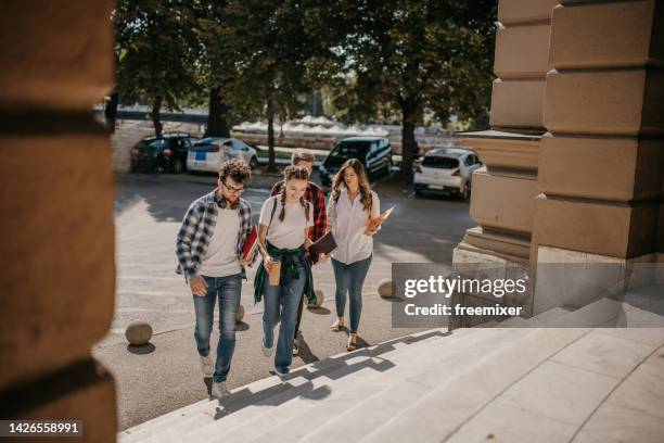 grupo de amigos charlando al llegar al campus - college campus students fotografías e imágenes de stock