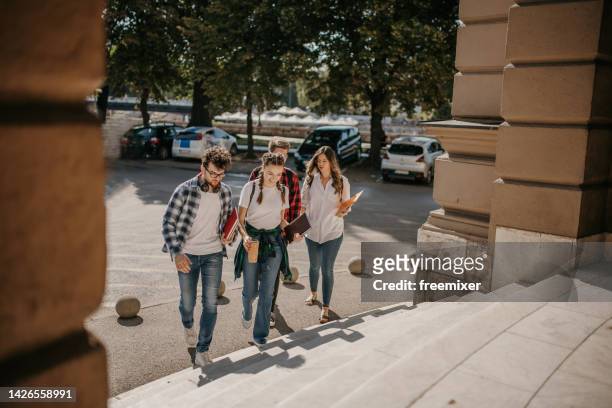 group of friends chatting while arriving on campus - campus stockfoto's en -beelden