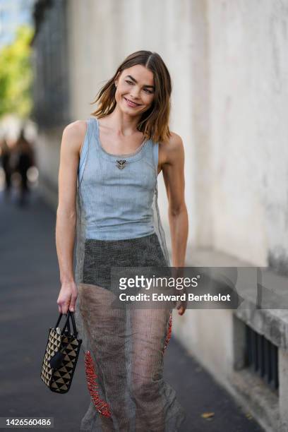 Guest wears a white tank-top from Prada, a pale gray tank-top / red embroidered rhinestones / long dress from Prada, black shorts, a black and beige...