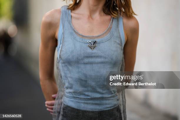 Guest wears a white tank-top from Prada, a pale gray tank-top / red embroidered rhinestones / long dress from Prada, black shorts, outside Prada,...