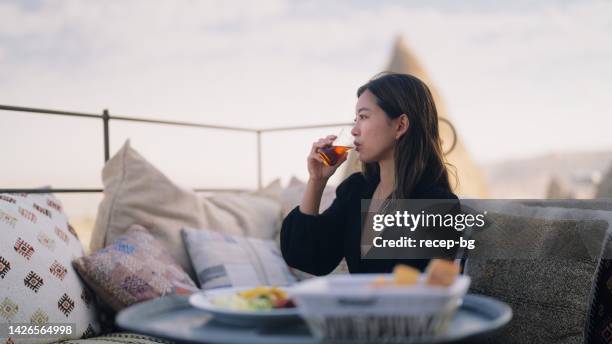 female tourist enjoying having breakfast on rooftop of hotel - premium tea bildbanksfoton och bilder