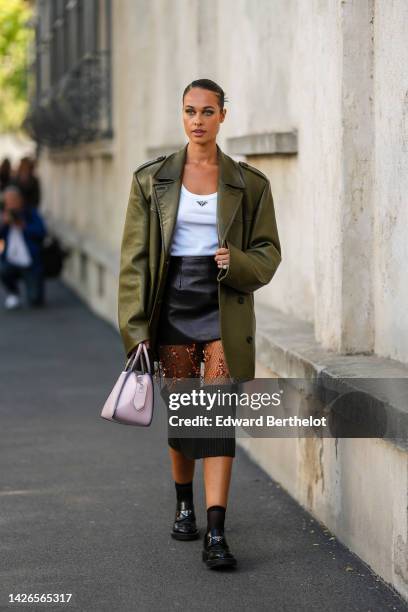 Sarah Lysander wears a white tank-top from Prada, a multi materials black shiny leather / mesh with embroidered range sequined flower pattern / black...