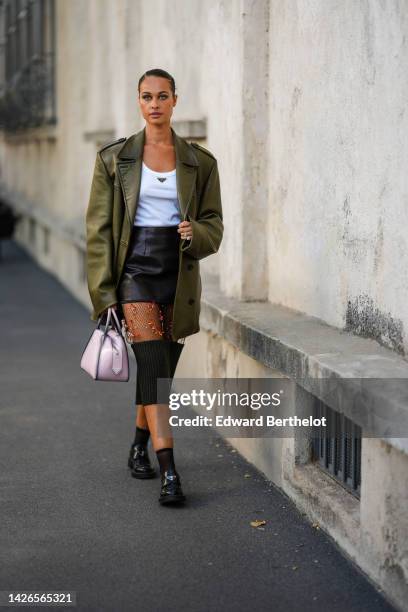 Sarah Lysander wears a white tank-top from Prada, a multi materials black shiny leather / mesh with embroidered range sequined flower pattern / black...