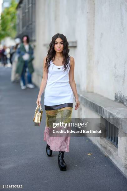 Guest wears a white tank-top from Prada, a multi material black leather / yellow satin / pink satin long skirt from Prada, a gold shiny varnished...