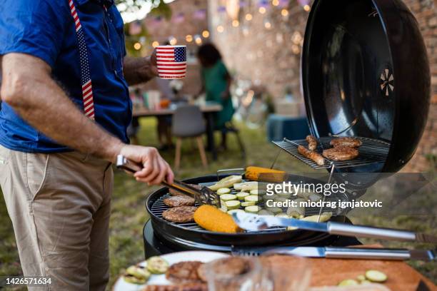 senior man grilling food for american national holiday in a back yard - 4th of july bbq stock pictures, royalty-free photos & images