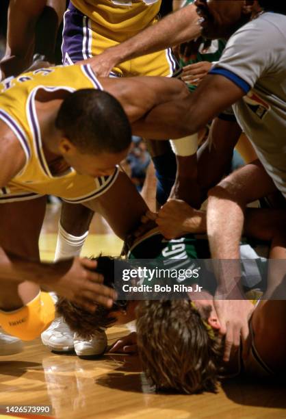 Officials try to separate Celtics Danny Ainge and Lakers Kurt Rambis as Lakers Bryan Scott is held back during 1985 NBA Finals between Los Angeles...
