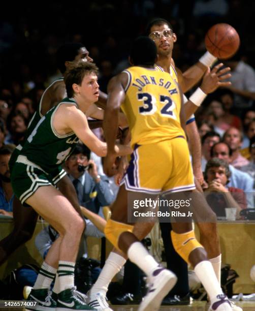 Lakers Kareem Abdul-Jabbar looks to pass to Magic Johnson who is covered by Celtics Danny Ainge during 1985 NBA Finals between Los Angeles Lakers and...