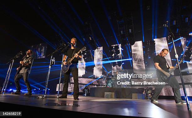 Musicians Ryan Peake, Chad Kroeger, Daniel Adair and Mike Kroeger of Nickelback perform at the I Wireless Center on April 10, 2012 in Moline,...