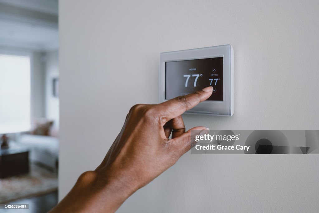 Woman Adjusts Thermostat