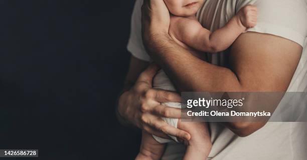 father holds a baby in his arms - baby skin fotografías e imágenes de stock
