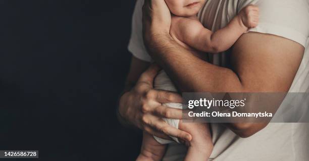 father holds a baby in his arms - father and baby stockfoto's en -beelden