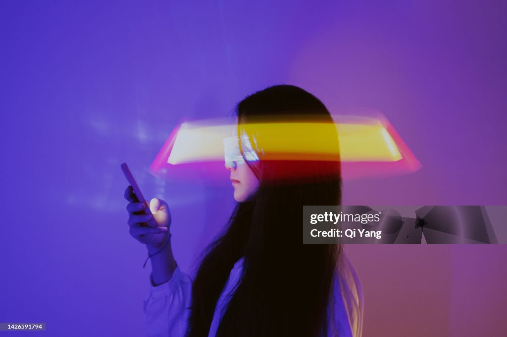 Asian woman using smartphone surrounded by beams of light