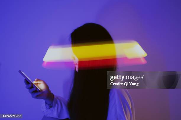 asian woman using smartphone surrounded by beams of light - hiding money stock pictures, royalty-free photos & images