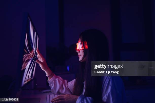 asian woman touching computer screen at home office late at night - digital transformation stock pictures, royalty-free photos & images