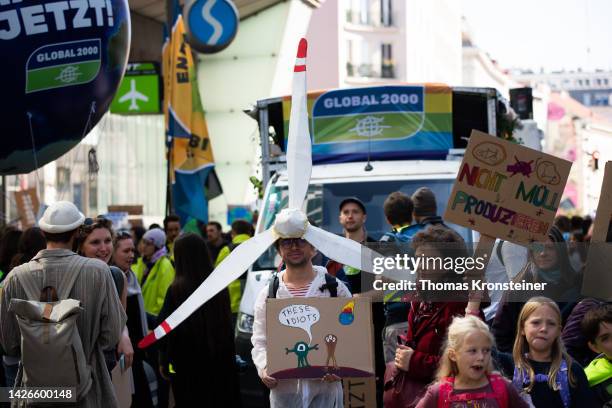 Supporter of the Fridays for Future climate action movement is dressed as a windmill during a global climate strike on September 23, 2022 in Vienna,...