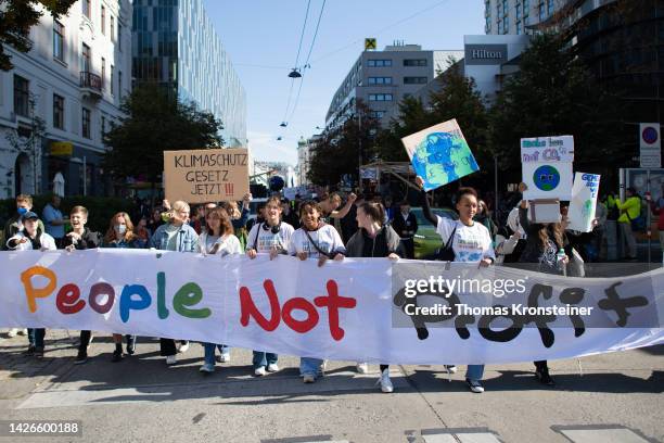 Supporters of the Fridays for Future climate action movement hold up a banner reading "People Not Profit" during a global climate strike on September...