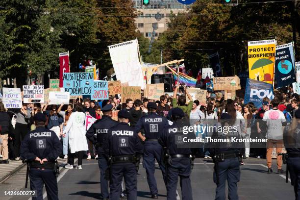 Police stand guard as supporters of the Fridays for Future climate action movement march during a global climate strike on September 23, 2022 in...