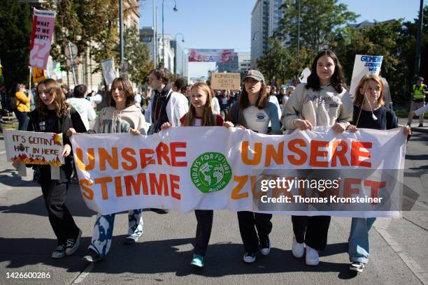 Supporters of the Fridays for Future climate action movement hold up a banner reading "Our Voice Our Future" during a global climate strike on...