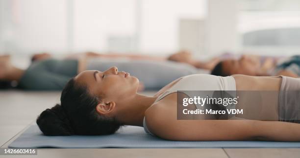 yoga, relax and meditation woman in studio workout class or cardio training gym. calm. wellness and fitness black woman lying on mat on gym ground or floor for inner healing and physical health - yoga studio stock pictures, royalty-free photos & images