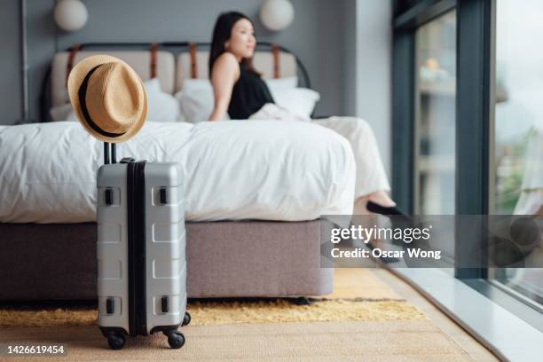 young woman taking rest after checking-in at luxury hotel - asian man suite stock-fotos und bilder