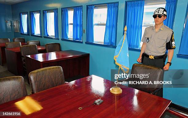 This photo taken on August 11, 2011 shows a South Korean soldier standing guard inside the UN conference room directly on the demarcation line, at...