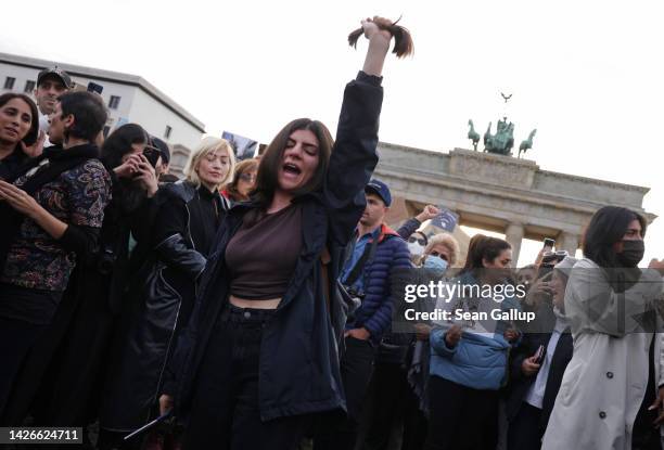 Female protester yells after cutting her hair with scissors as an act of solidarity with women in Iran during a demonstration against the death of...