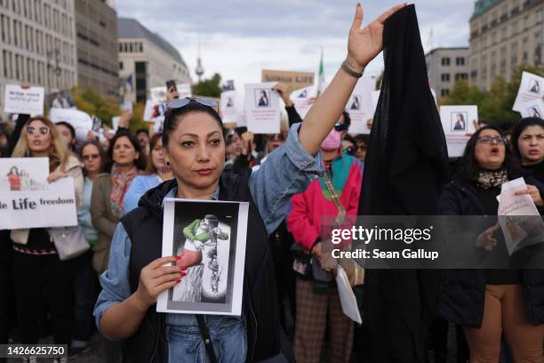 Protesters, including one woman holding up a headscarf, gather to demonstrate against the death of Mahsa Amini in Iran on September 23, 2022 in...