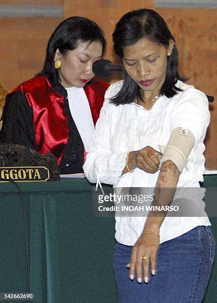 Balinese waitress, Ni Wayan Suryani, a victim of the October bombing shows her scar to prosecutors as she testifies during the trial of Ali Imron in...